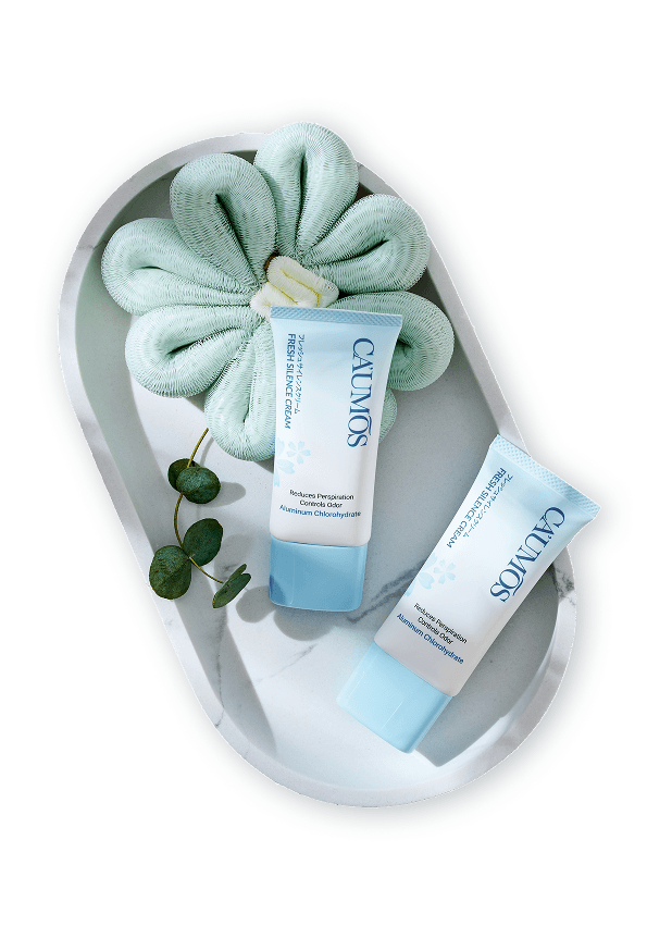 Caumos Fresh Silence Cream đặt trên khay đá cẩm thạch cùng hoa xơ mướp và lá bạc đàn